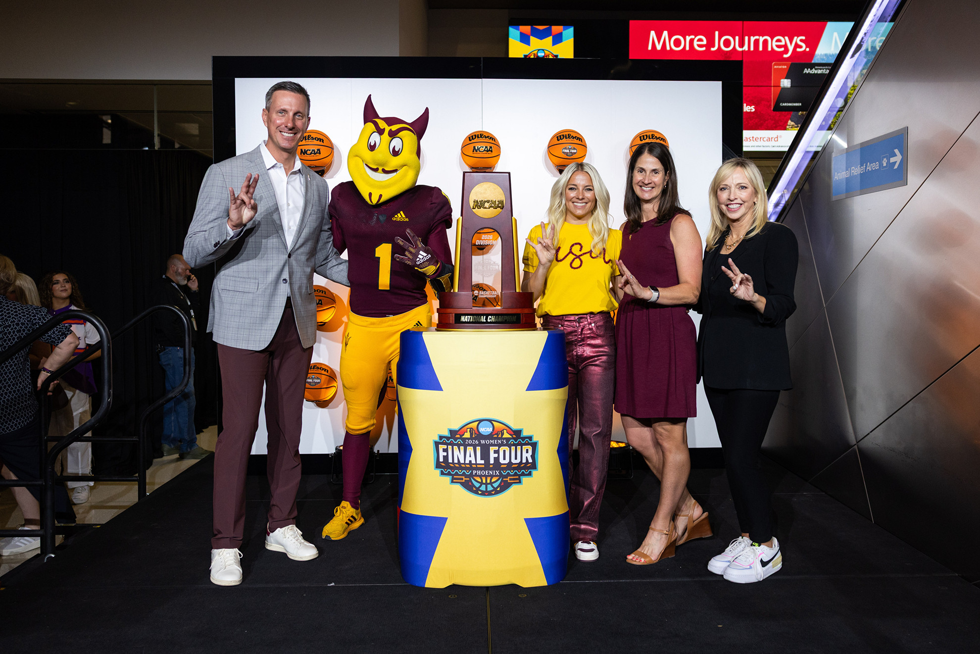 Womens Final Four Countdown Clock Unveiling From left to right, Graham Rossini, Sparky, Molly Miller, Christina Wombacher and CEO of the 2026 Women’s Final Four Committee Jay Parry pose with the NCAA Women's Basketball Championship Trophy at the unveling of the NCAA Final Four Tournament Clock at Phoenix Sky Harbor Airport on August 19, 2025.